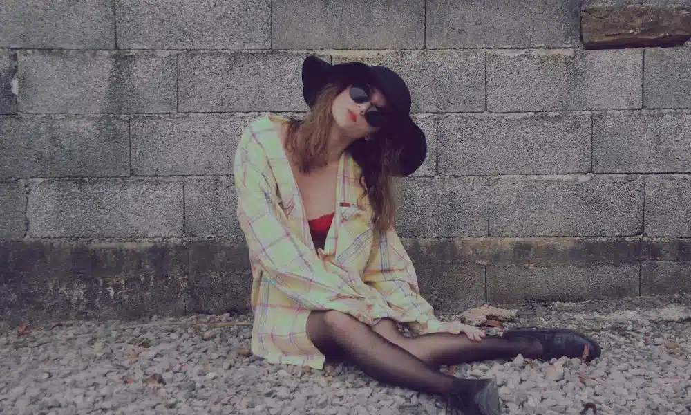 woman leaning on wall while sitting on floor