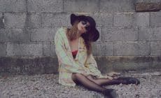 woman leaning on wall while sitting on floor