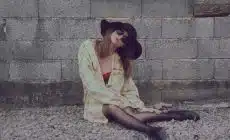 woman leaning on wall while sitting on floor