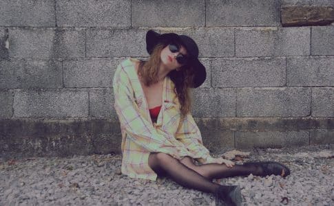 woman leaning on wall while sitting on floor